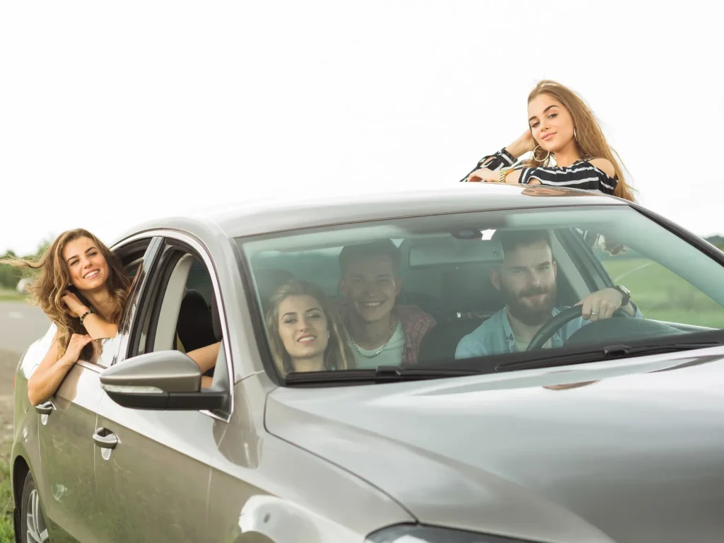 Tineri într-o mașină interesați de o asigurare auto începători pentru un preț mai mic