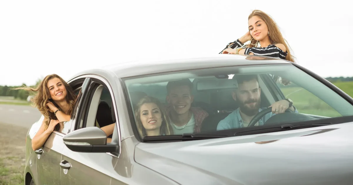 Tineri într-o mașină interesați de o asigurare auto începători pentru un preț mai mic